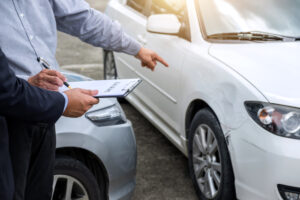 Cheap Car Insurance for a Bad Driving Record - An image of a car insurance inspector, inspecting a vehicle.