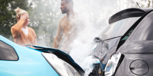 A woman and man standing near a car accident.