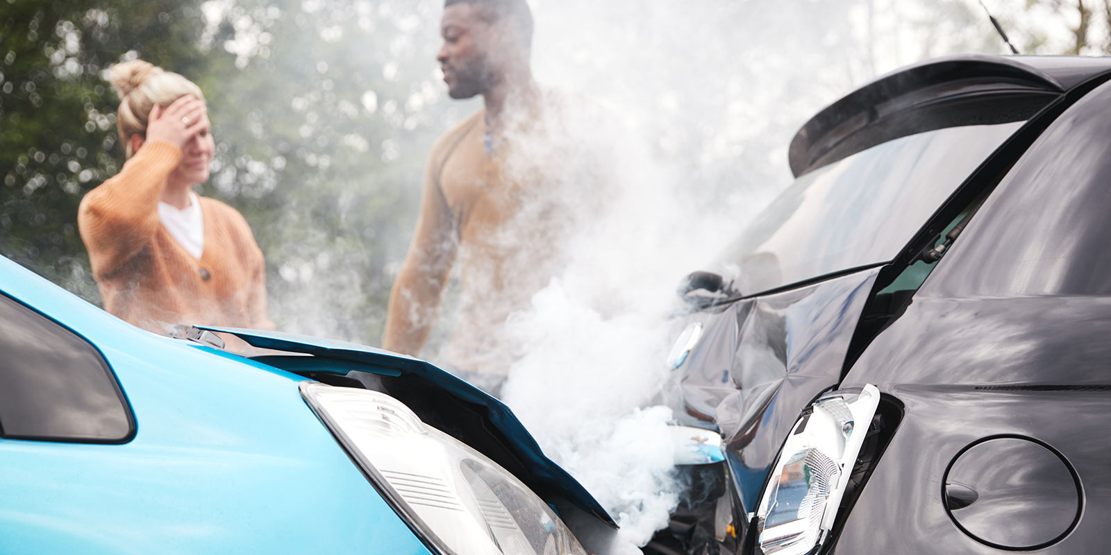 A woman and man standing near a car accident.