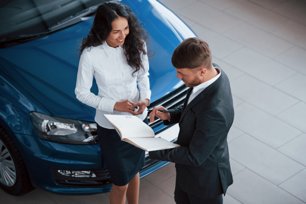 Smiling client receiving keys and policy guidance from a GoAuto insurance representative