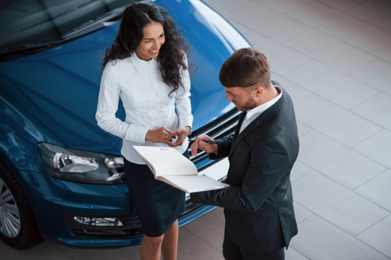 Smiling client receiving keys and policy guidance from a GoAuto insurance representative