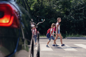Pedestrians using a marked crosswalk at an urban intersection highlighting pedestrian safety